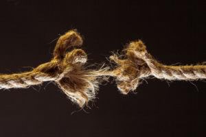A frayed rope about to break represents stress between two people in a relationship.